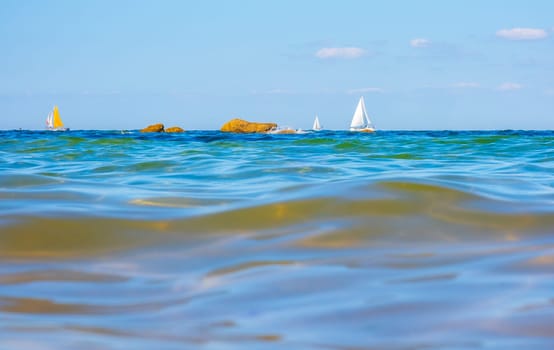Boats and waves seen by a swimmer at sea level, photography taken in Vendée, France