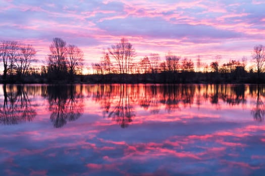 Nightscape at Adour French river in blazing red sunset with dramatic clouds floating. Photography taken in France