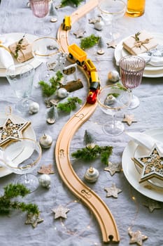 Festive Christmas place setting with small wooden railway