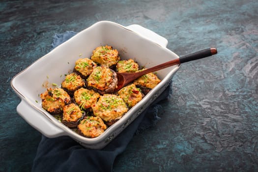 Oven baked stuffed mushrooms - champignons with cream cheese and dried tomatoes in casserole