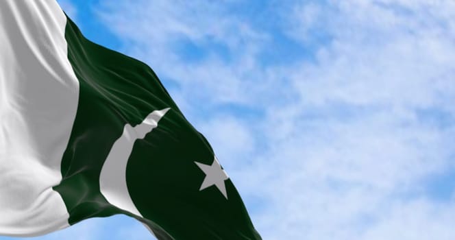 Close-up of Pakistan National flag waving on a clear day. Green with white band on hoist  white crescent moon and five-pointed star. 3d illustration render. Rippling fabric. Selective focus