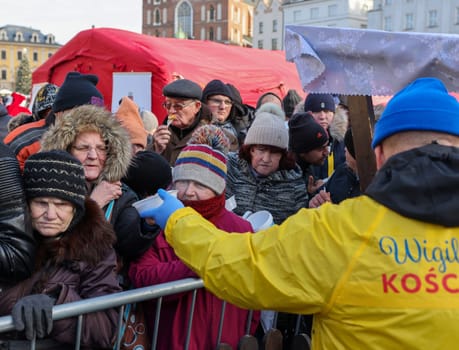 Krakow, Poland - Dec 17, 2023: Christmas Eve for poor and homeless on the Main Square in Cracow. The group Kosciuszko prepares the greatest eve in the open air in Krakow