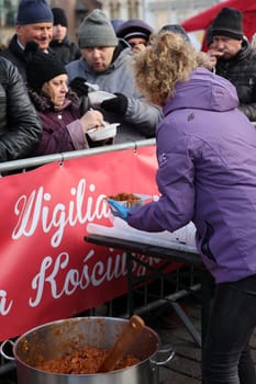 Krakow, Poland - Dec 17, 2023: Christmas Eve for poor and homeless on the Main Square in Cracow. The group Kosciuszko prepares the greatest eve in the open air in Krakow