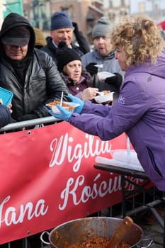 Krakow, Poland - Dec 17, 2023: Christmas Eve for poor and homeless on the Main Square in Cracow. The group Kosciuszko prepares the greatest eve in the open air in Krakow
