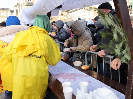 Krakow, Poland - Dec 17, 2023: Christmas Eve for poor and homeless on the Main Square in Cracow. The group Kosciuszko prepares the greatest eve in the open air in Krakow