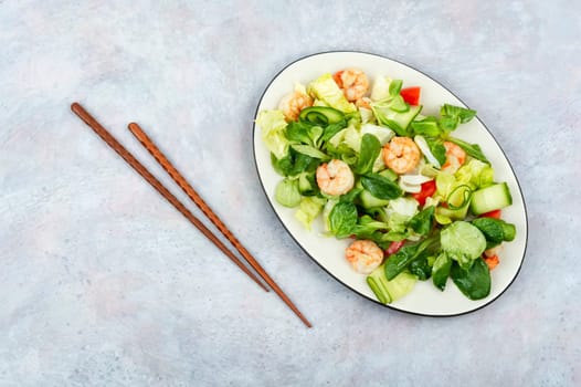 Plate with salad of fresh vegetables, mixed greens and shrimp. Prawns salad. Clean food, top view, copy space.