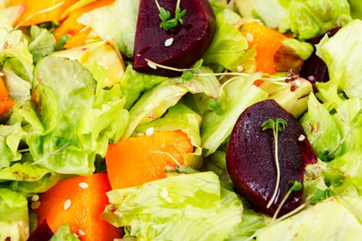Autumn salad of baked pumpkin, beetroot and greens in a plate on the table. Healthy eating
