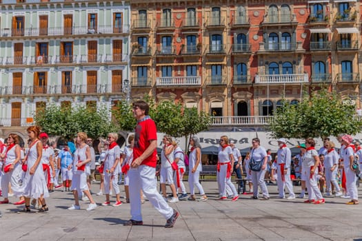 Pamplona, Spain: 09 July 2023: People celebrate San Fermin festival in traditional white abd red clothing with red necktie, Pamplona, Navarra, Spain.