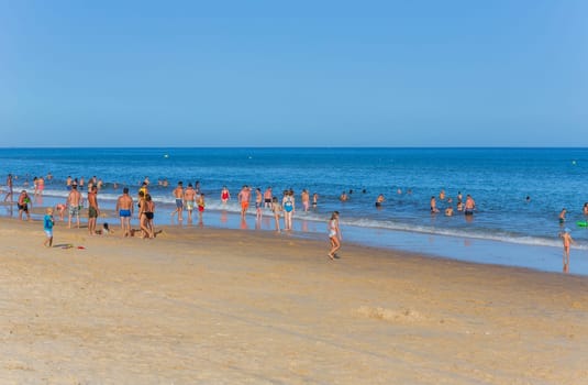 Tavira, Portugal - August 15, 2023: People at the famous beach of Tavira island in Tavira. This beach is a part of famous tourist region of Algarve.