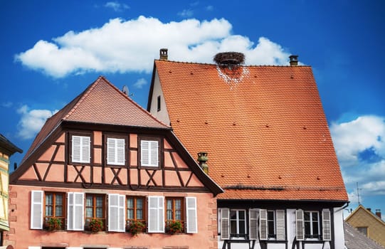 a traditional Alscaian house with a stork's nest on the roof