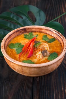 Bowl of tom yum soup on wooden background