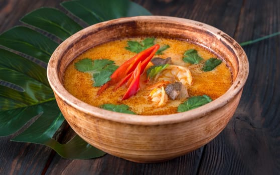 Bowl of tom yum soup on wooden background