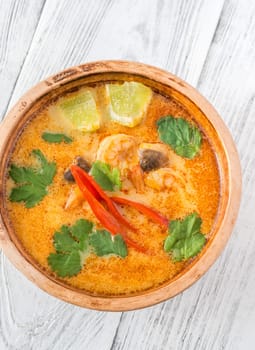 Bowl of tom yum soup on wooden background
