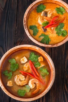 Bowls of tom yum soup with and without coconut milk