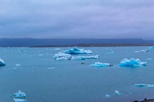 Beautiful blue icebergs reflected in the Jokulsarlon glacial lagoon. Southern Iceland. Part of the Vatnajokull National Park and Vatnajokull glacier, the largest glacier in Europe.