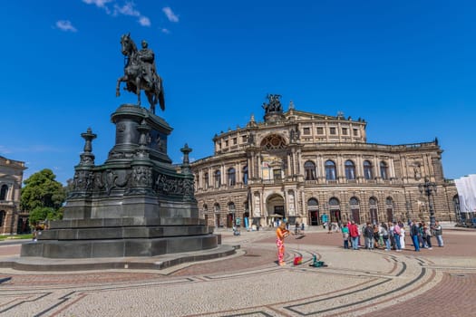 Dresden, Germany - 10 August 2023: State Opera House (Semperoper) and King Johann statue on Theaterplatz square