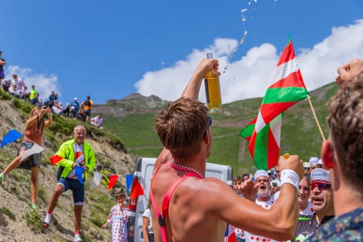 Col du Tourmalet, France - July 06 2023: Cycling fans waiting for the buch at the top of the Col du Tourmalet in Pyerenees mountains during the stage 6 of Le Tour de France 2023