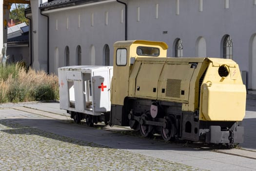 Walbrzych, Poland - October 1, 2021: The Old Mine Science and Art Centre, museum located in the historic Julia Coal Mine. Locomotive and a medical wagon to transport miners underground