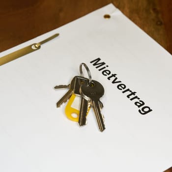 Keys and rental contract for a new apartment are on a table