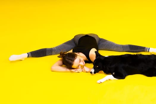 Woman with cute dog border collie is in a studio. Sport with pet