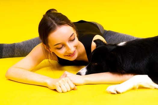 Woman with cute dog border collie is in a studio. Sport with pet