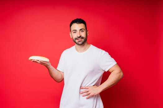 Man holding freshly baked bread in hands isolated on a red background