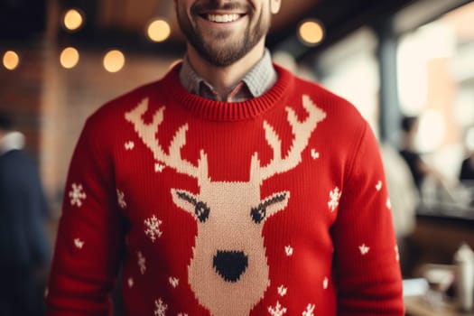 Merry fun young man wearing Christmas sweater with reindeer standing next to Christmas tree in workspace. Christmas time. Merry Christmas. Holiday concept