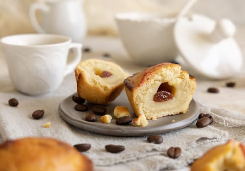 Pasticciotto leccese pastry filled with egg custard cream and sour cherry jam. Pieces of pasticiotto on a plate on a white rustic wooden table, typical apulian breakfast with coffee, close up