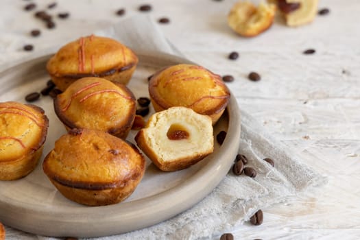 Pasticciotto leccese pastry filled with egg custard cream and sour cherry jam. Pieces of pasticiotto on a plate, typical apulian breakfast, close up Table decorated with coffee beans