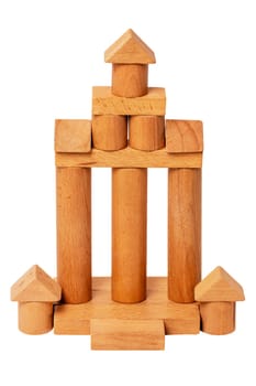 Wooden house isolated. Wooden toy castle constructed of cubes, cylinders, triangles and other shapes made of beech wood. Clipping path. Wooden toy blocks. Macro.
