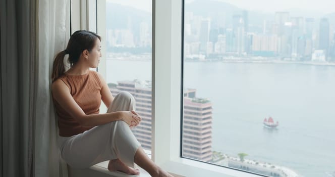 Young woman look at the city view at hotel room