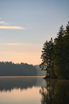 on a lake in Sweden in Smalland. Rock in foreground, blue water, sunny sky, green forests. Relaxation and silence on vacation