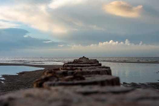 Breakwater on the Baltic Sea coast at low tide with sky and clouds