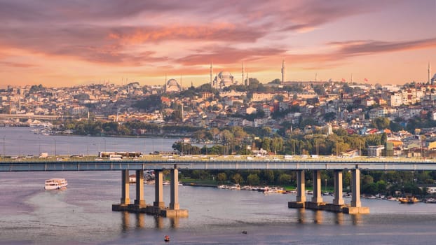 Aerial view from Pierre Loti popular hilltop park of the Halic Bridge, spanning the Golden Horn in Istanbul, Turkey, with background of city skyline, with historic mosques towering above the city