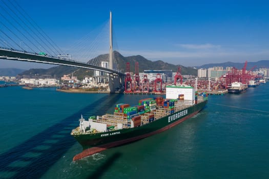Kwai Tsing, Hong Kong 04 December 2019: Top view of cargo ship pass though suspension bridge