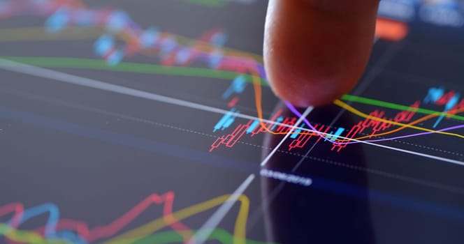 Finger touch on screen with stock market data