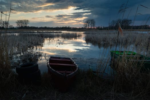 Smal boats on the shore of the lake on a cloudy evening