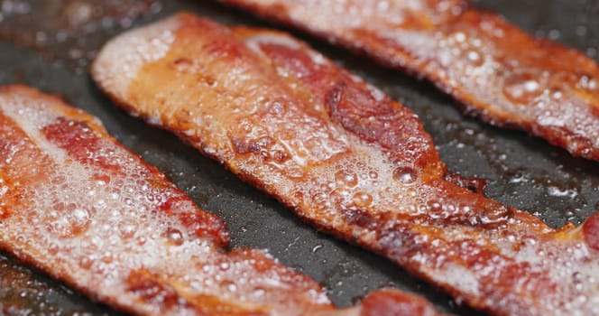 Fry bacon in pan in kitchen for breakfast