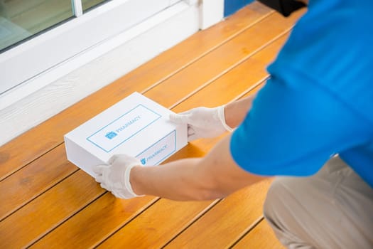 Delivery hands with gloves transport holding medication package box first aid shipment from pharmacy hospital delivery on floor at door front home patient, Buy online clinic retail Rx drug store