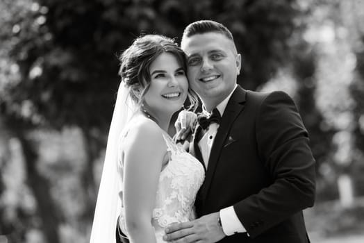 the groom in a brown suit and the bride in a white dress in an urban atmosphere