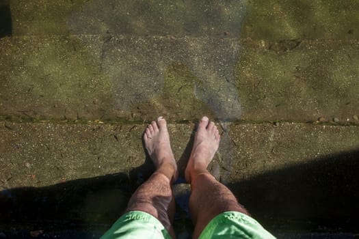 Natural massage therapy with fish on the banks of the Arrago river, Perales del Puerto natural swimming pool, Sierra de Gata, Caceres, Extremadura, Spain