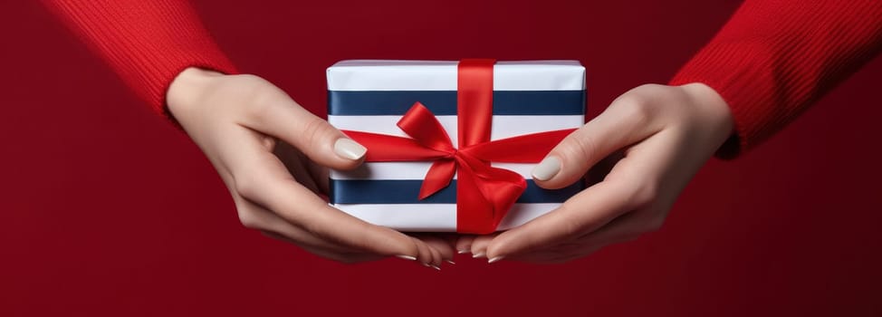 christmas gift wrapping package with striped ribbon by lady hands.