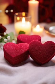two red heart shaped cakes sitting on a table with red powder.