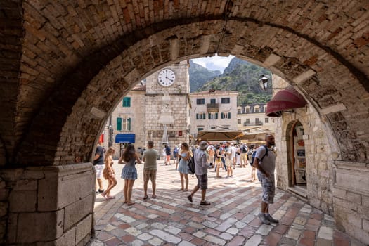 Kotor, Montenegro - June 26, 2023: Arms Square with medieval Clock Tower, view from the Sea Gate