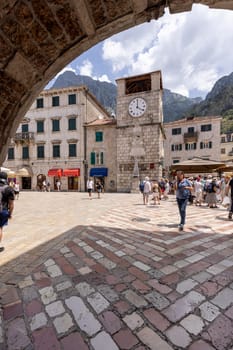 Kotor, Montenegro - June 26, 2023: Arms Square with medieval Clock Tower, view from the Sea Gate