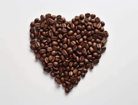 a heart of coffee beans was made on a white background.