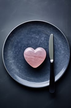 an empty plate with a pink heart on it and a fork and knife on the top.