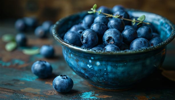 Freshly picked blueberries in blue bowl. Juicy and fresh blueberries with green leaves on rustic table. Bilberry on wooden Background. Blueberry antioxidant. Concept for healthy eating and nutrition Copy space