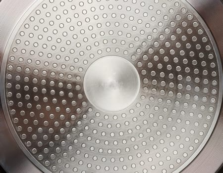 The bottom of a metal frying pan, close up