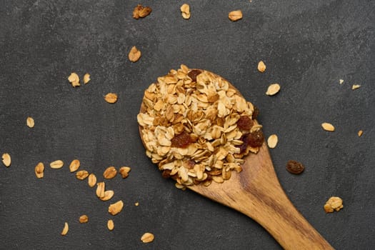Oatmeal, raisins, cashews and almonds. Granola in a wooden spoon, top view